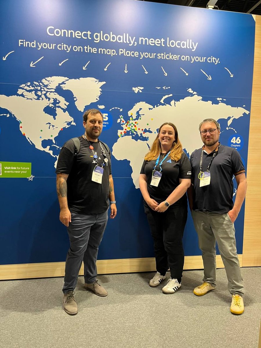 Davide e Valerio con la community manager di Atlassian Morbhen Rattray. Alle loro spalle un fondale con l'Europa disegnata dal titolo "Connect globally, meet locally"